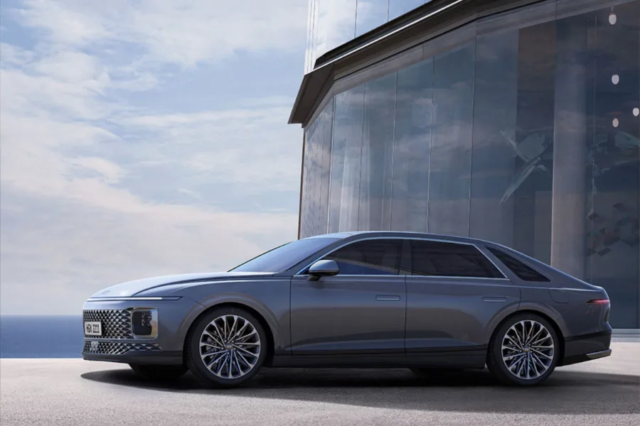 Premium grey sedan beside a modern glass building