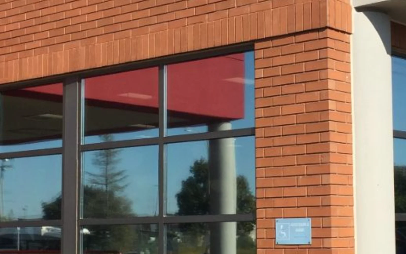 Exterior of a Hamilton-area commercial building with continuous street-level storefront glazing after Skyline film installation
