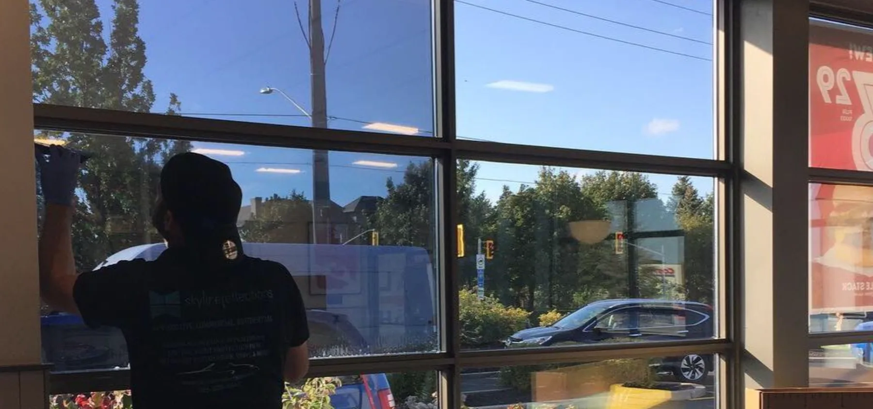 Installer moving along a run of commercial glazing during film installation