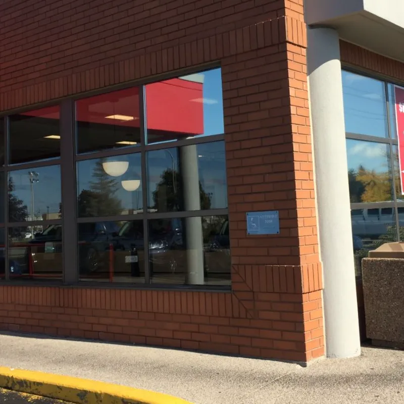 Corner of a commercial building with finished window film across the ground-floor glazing