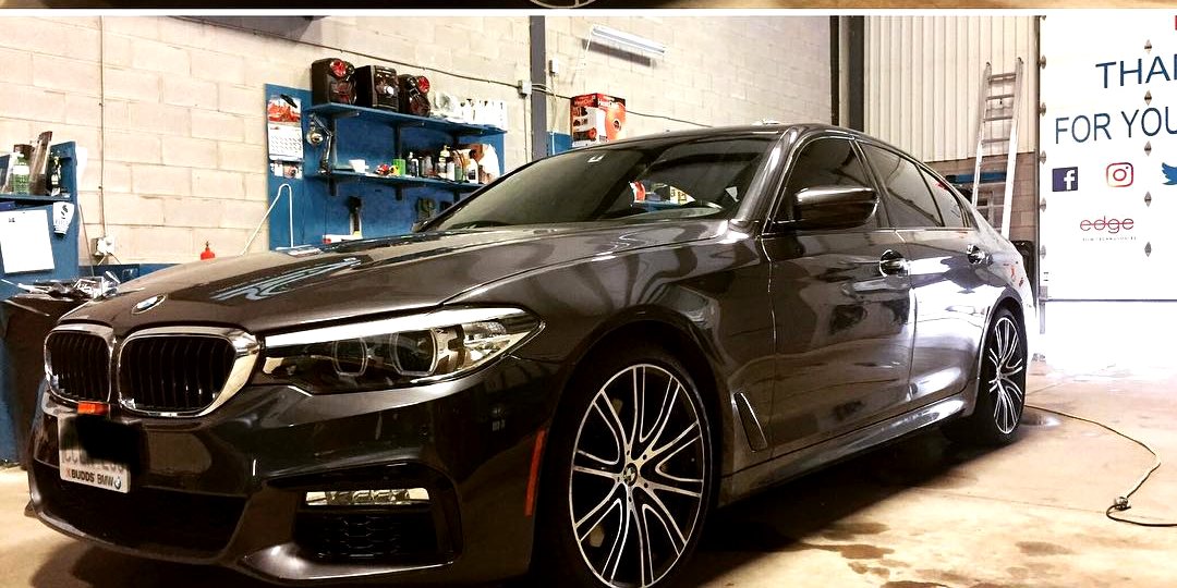 Finished black BMW sedan with tinted glass inside the Skyline Reflections Hamilton shop