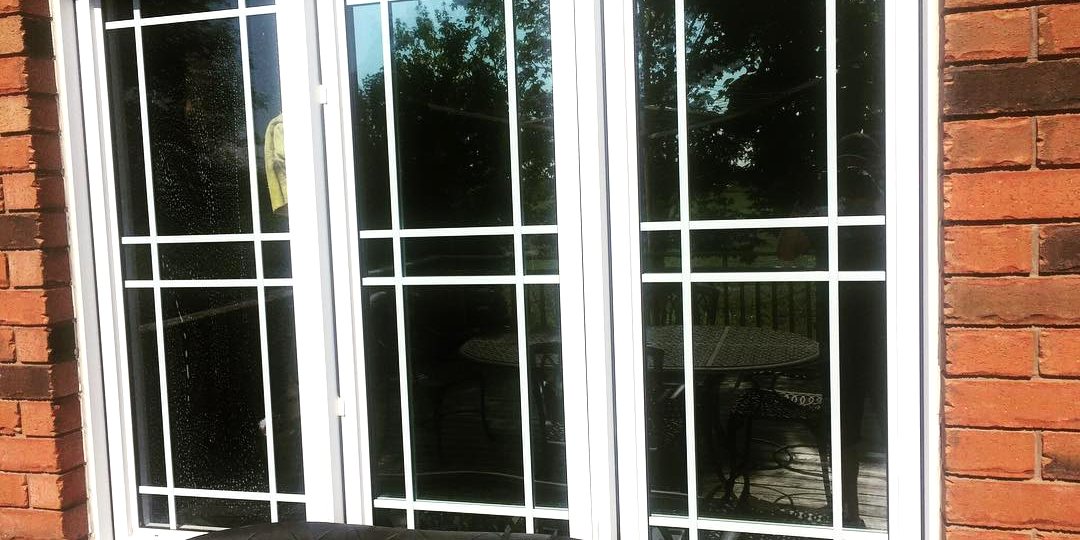 Residential bay windows with window film installed, photographed from outside the home