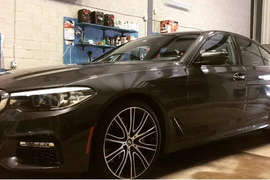 Black BMW sedan with tinted side and rear glass inside the Skyline Reflections shop